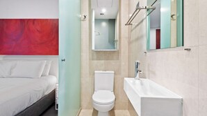 Een moderne badkamer met toilet, wastafel en douche.