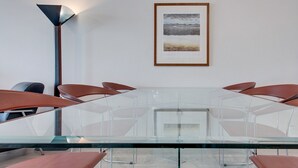 A conference room with a glass table, brown chairs, a framed picture on the wall, and a floor lamp. - Wake up to Sydney Harbour (Balmain East)