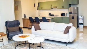 A modern living room with a sofa, two coffee tables, and a chessboard. - Norden Suites (Mombasa)