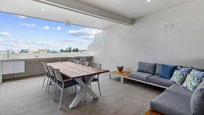 Une cuisine moderne avec un coin repas, un canapé et une vue sur le ciel.