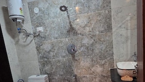A bathroom with a shower, a toilet, a sink, and a window.