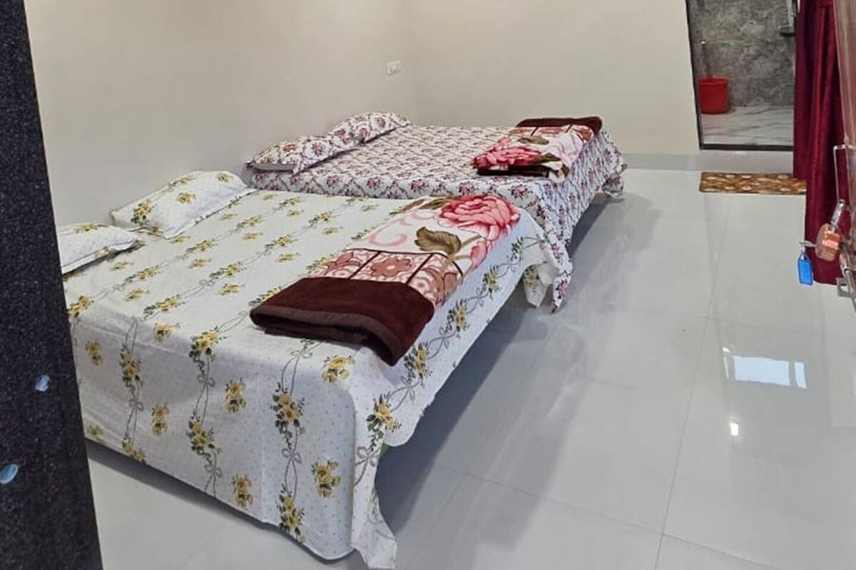 A bedroom with a bed, a ceiling fan, and a shower area.