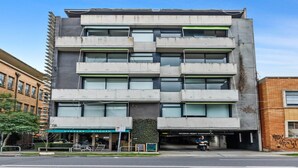 A multi-story building with a modern architectural style, featuring a flat roof and a mix of window sizes. - Vibrant 2-Bed Apartment Near St Kilda Beach (St Kilda)