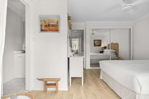 Ein Schlafzimmer mit Bett, Schreibtisch, Stuhl, Kleiderschrank und einem Bild an der Wand.