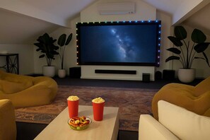A home theater with a large screen, popcorn, and seating. - Fun for Families: Location, Cinema, Games, Wifi (Leederville)