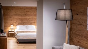 Ein modernes Zimmer mit einem Bett, einem Sofa, einem Couchtisch und einer Lampe.