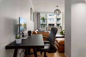 A modern living room with a desk, a sofa, and a dining table. - Spacious 1 Bed Near Manly Beach (Manly)