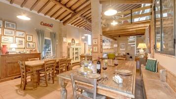 Un comedor con muebles de madera, una zona de cocina con pared de ladrillo y un cartel que dice 'Cuisine'.
