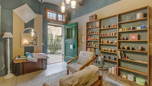 A room with a sofa, a chair, a table, a bookshelf, and a door leading outside. - Torre Rasa Agriturismo Apartments (Castelfiorentino)