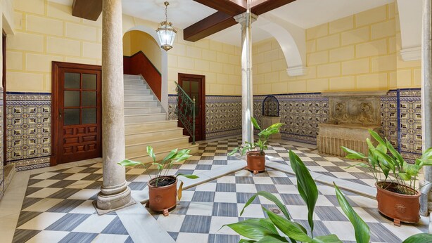 A checkered floor, columns, a staircase, and potted plants in a building's interior. - San Jeronimo Suite. Free Parking (Granada)