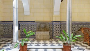 A checkered floor, a column, a patterned wall, and a chair. - San Jeronimo Suite. Free Parking (Granada)