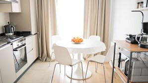 A modern kitchen with a dining table, chairs, and a fruit bowl. - Stylish Duplex with Private Terrace & Golden Horn View – 5 min to Istiklal (İstanbul)