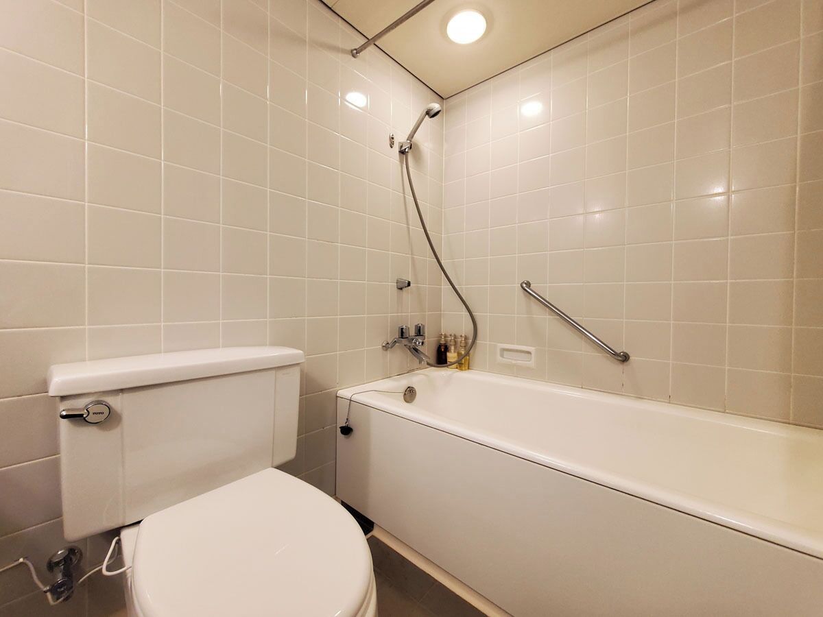 A bathroom with a toilet, a bathtub, and a shower.