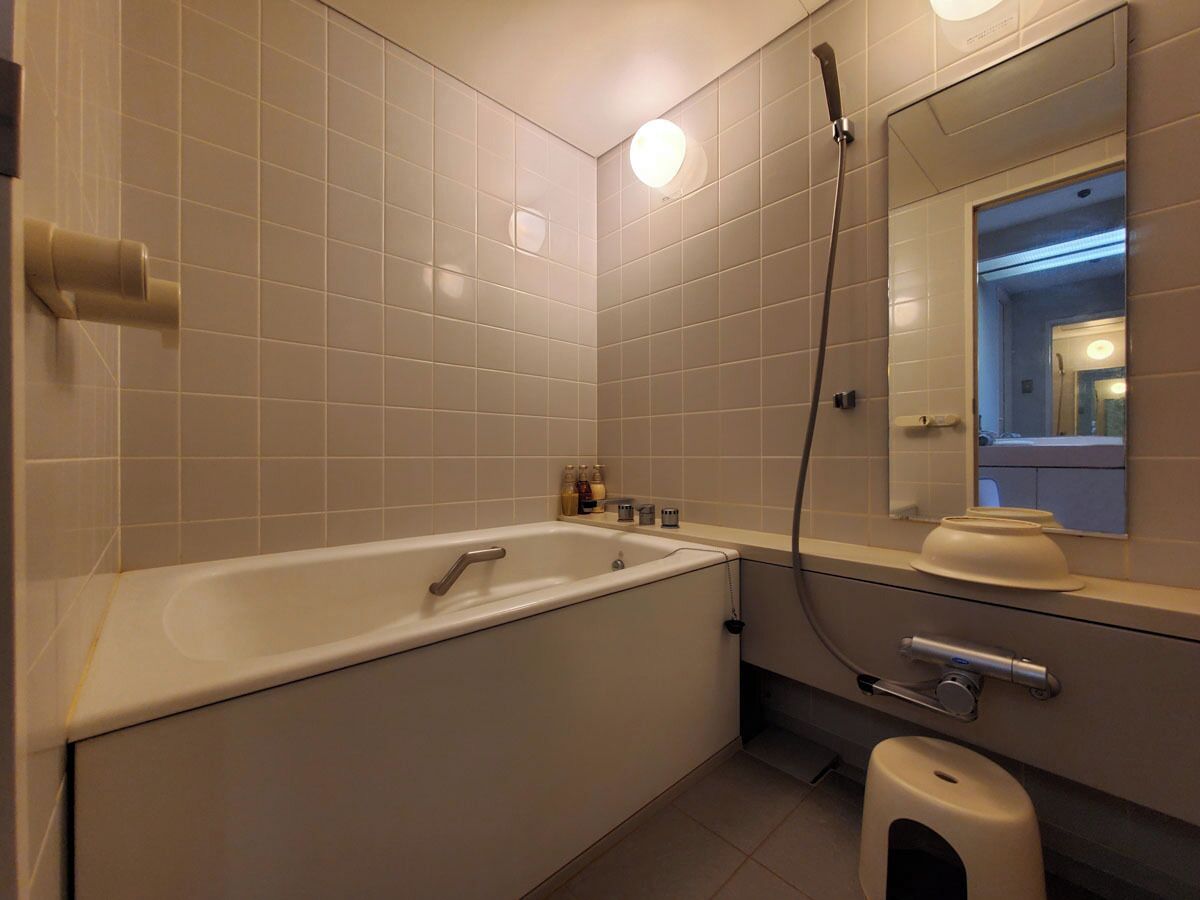 A bathroom with a bathtub, a toilet, a sink, a mirror, and a shower.
