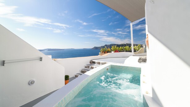A rooftop pool with a view of the sea and mountains.