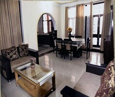 A living room with a sofa, coffee table, and dining area with chairs and a table.