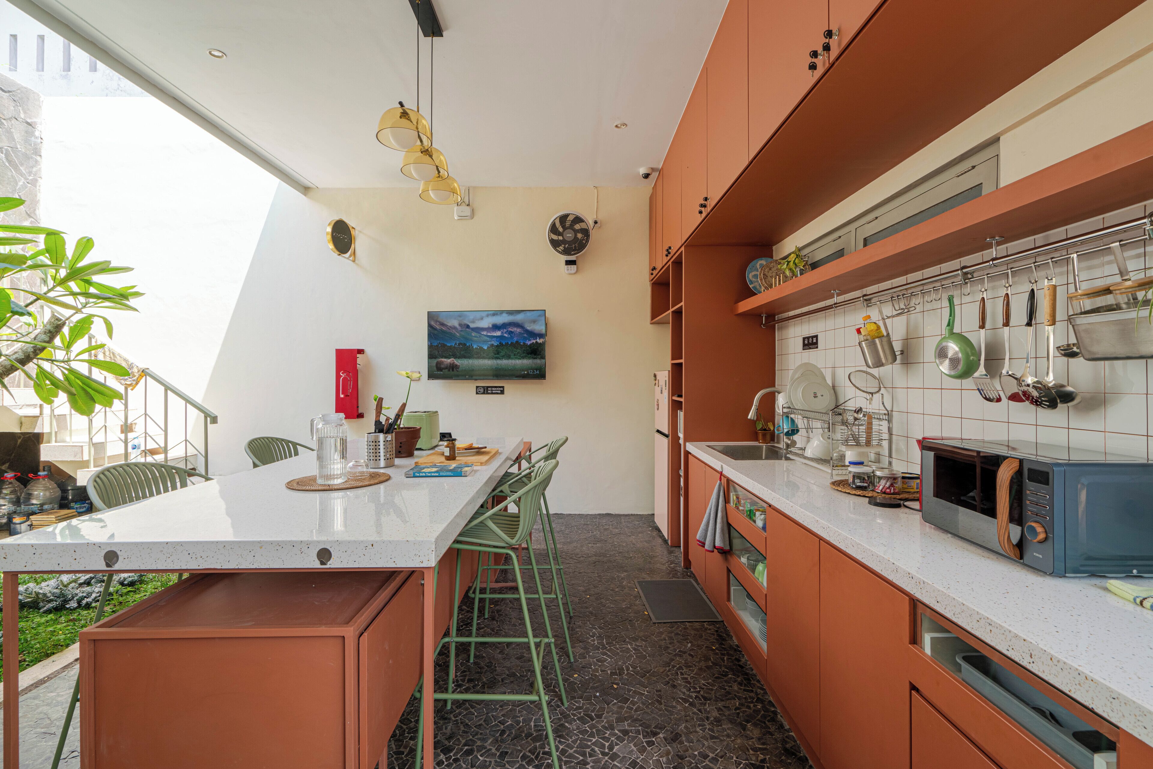 A modern kitchen with a central island, bar stools, and a dining area with chairs.
