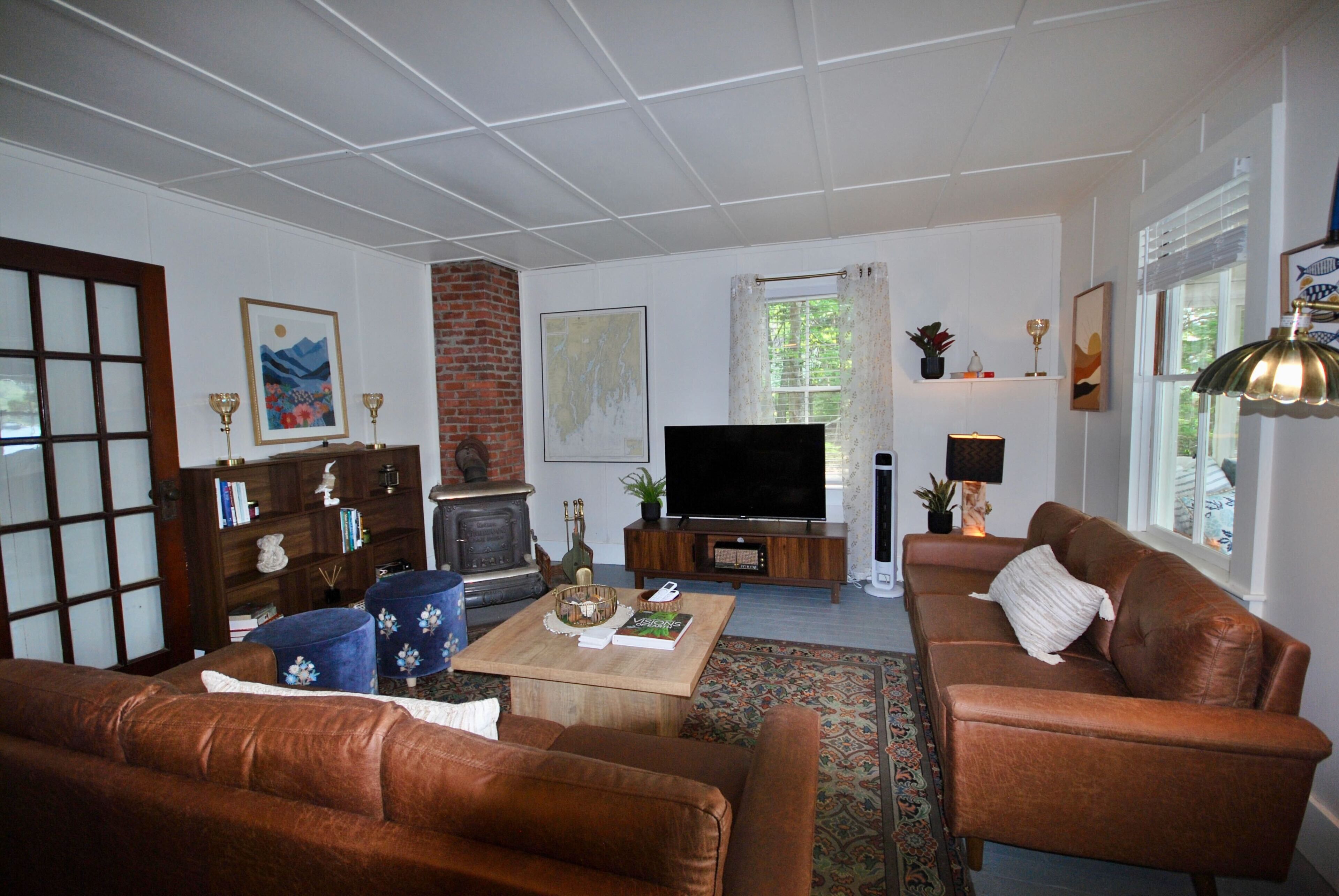 Una sala de estar con chimenea, televisor y dos sofás.