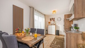 Una cocina moderna con encimera de madera, un fregadero y una zona de comedor con una mesa dispuesta para el desayuno.