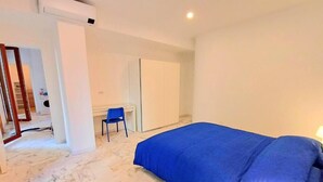 A room with a bed, a desk, a chair, and a wardrobe. - Prince Apartment (Napoli)