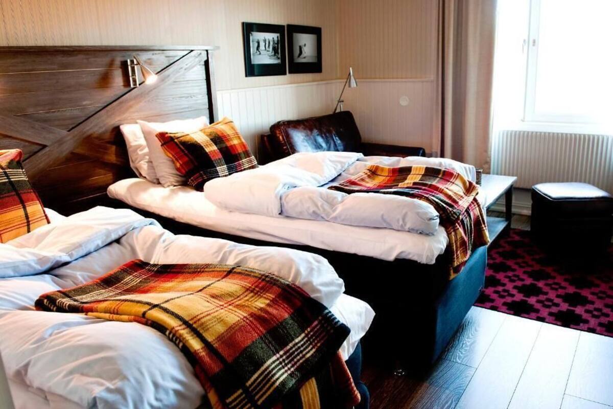 Een hotelkamer met twee bedden, een bureau en een stoel.
