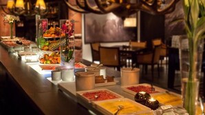 Ein reichhaltiges Buffet mit verschiedenen Speisen und Getränken, einer Kristallleuchter und einer Dekoration aus Hirschgeweihen.