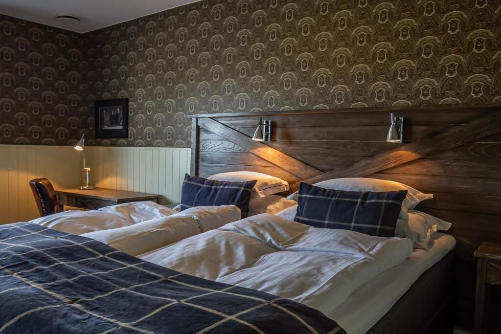 A hotel room with a bed, a desk, and a chair.