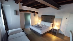 Una camera da letto con un letto, comodini, una sedia e una porta.