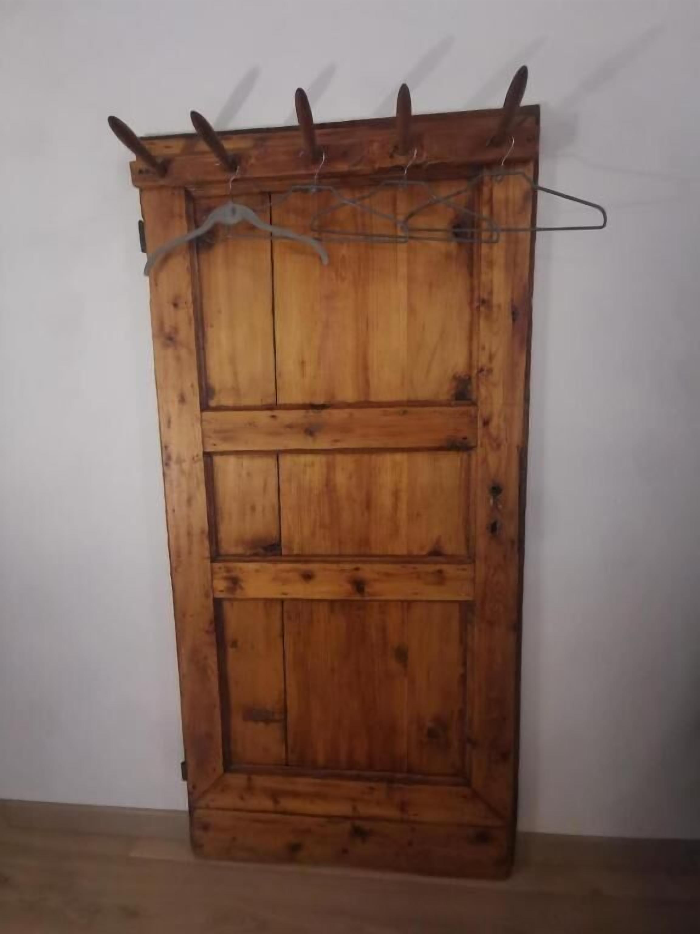 A wooden wardrobe with a metal hanger rack on top.