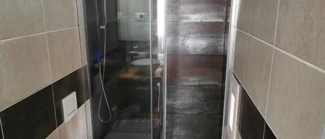 Une salle de bain équipée d’une douche, de toilettes et d’un lavabo.