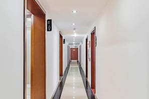 Ein Hotelgang mit Türen, einem Schild für die Damentoilette und einem sauberen, gefliesten Boden.