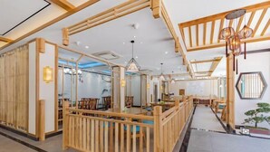 Een modern interieur met houten scheidingswanden, tafels, stoelen en een plafond met houten balken en hangende lampen.