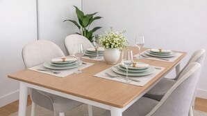 A dining table set with plates, glasses, and a vase of flowers. - Serene 3-Bed Retreat for 6 - Elegant Central Home (London)