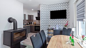 Une cuisine moderne avec des meubles de couleur sombre, un four encastré et une cuisinière noire.