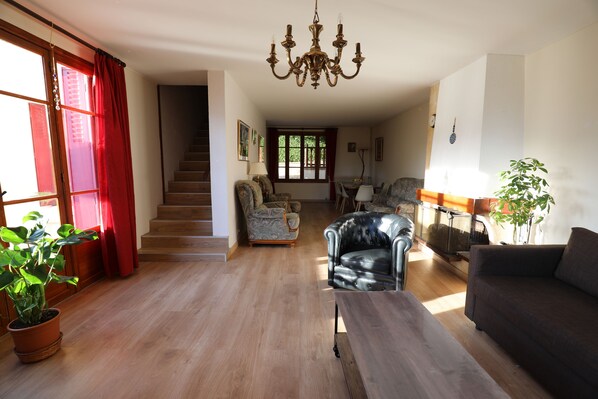 A spacious living room with a staircase, leather armchair, and a sofa. - Country house (Saint-Aubin-sur-Yonne)