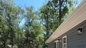 A covered deck with outdoor furniture, a barbecue, and a house in the background. - Dog Friendly! 254 a nite! 4Bed 3Bath! Free Island Parking! Just a skip to Beach! (Ocean Isle Beach)