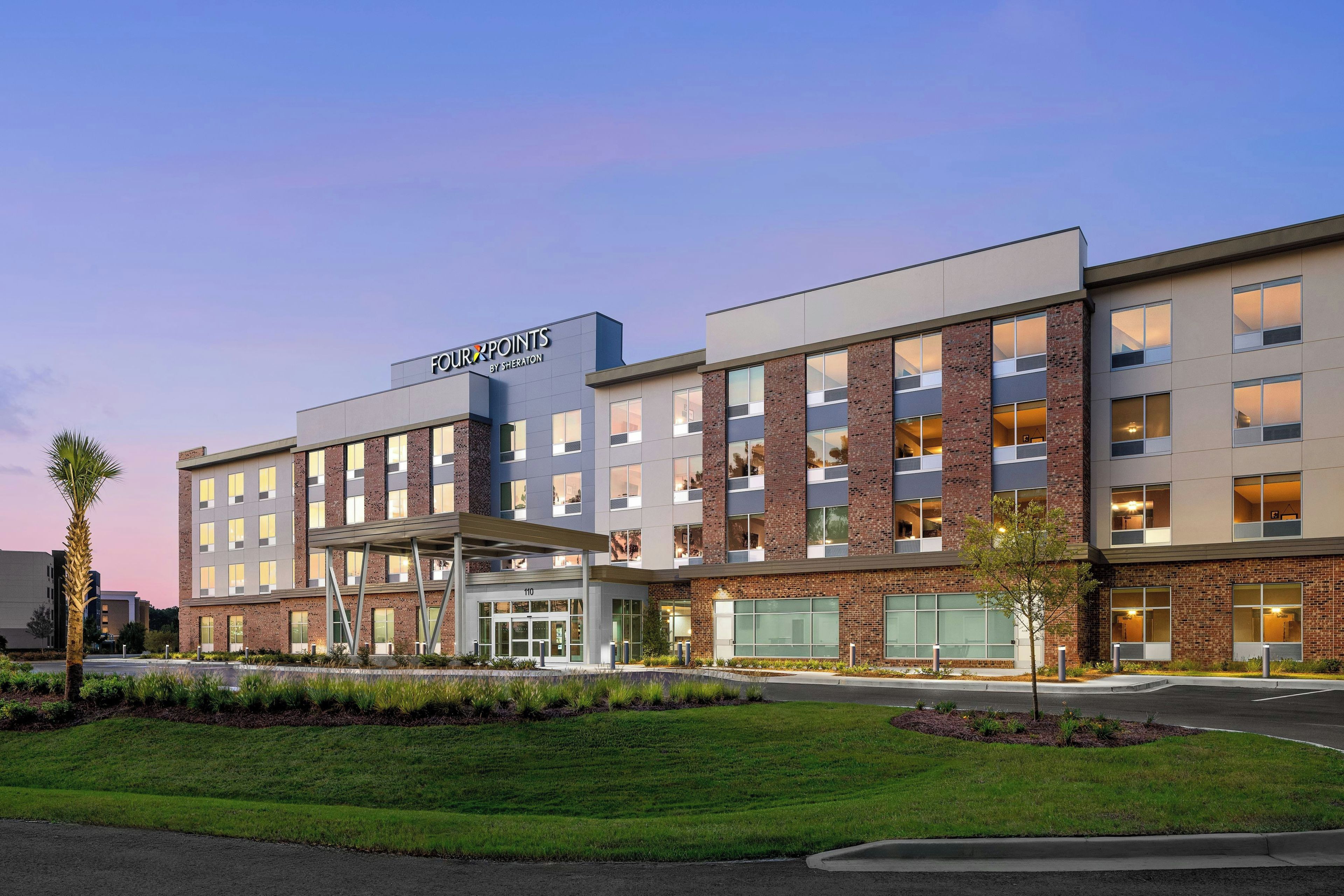 Un edificio moderno de hotel con un letrero que dice 'FOUR POINTS BY SHERATON'.
