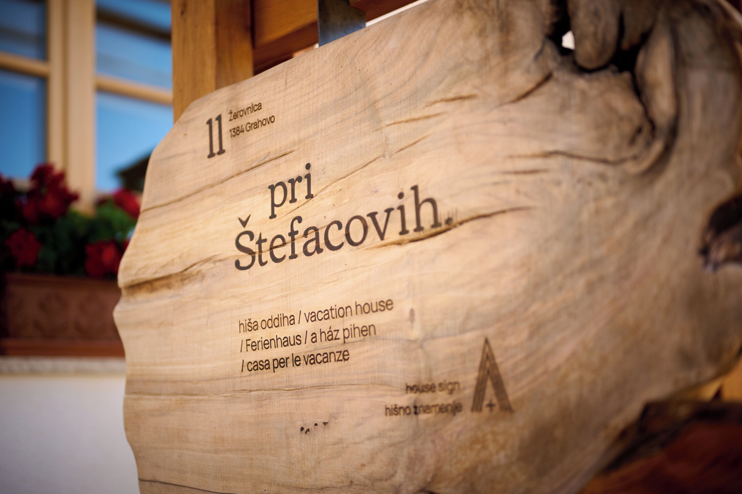 A wooden sign with the number 11 and the name 'Stefacovih.' It includes translations for 'vacation house' in multiple languages.
