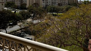 Un quartier résidentiel avec des immeubles à plusieurs étages, un ciel dégagé et des arbres au premier plan.
