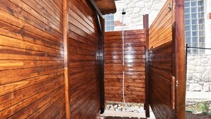 Une structure en bois avec une porte en métal, un mur en pierre et une fenêtre.