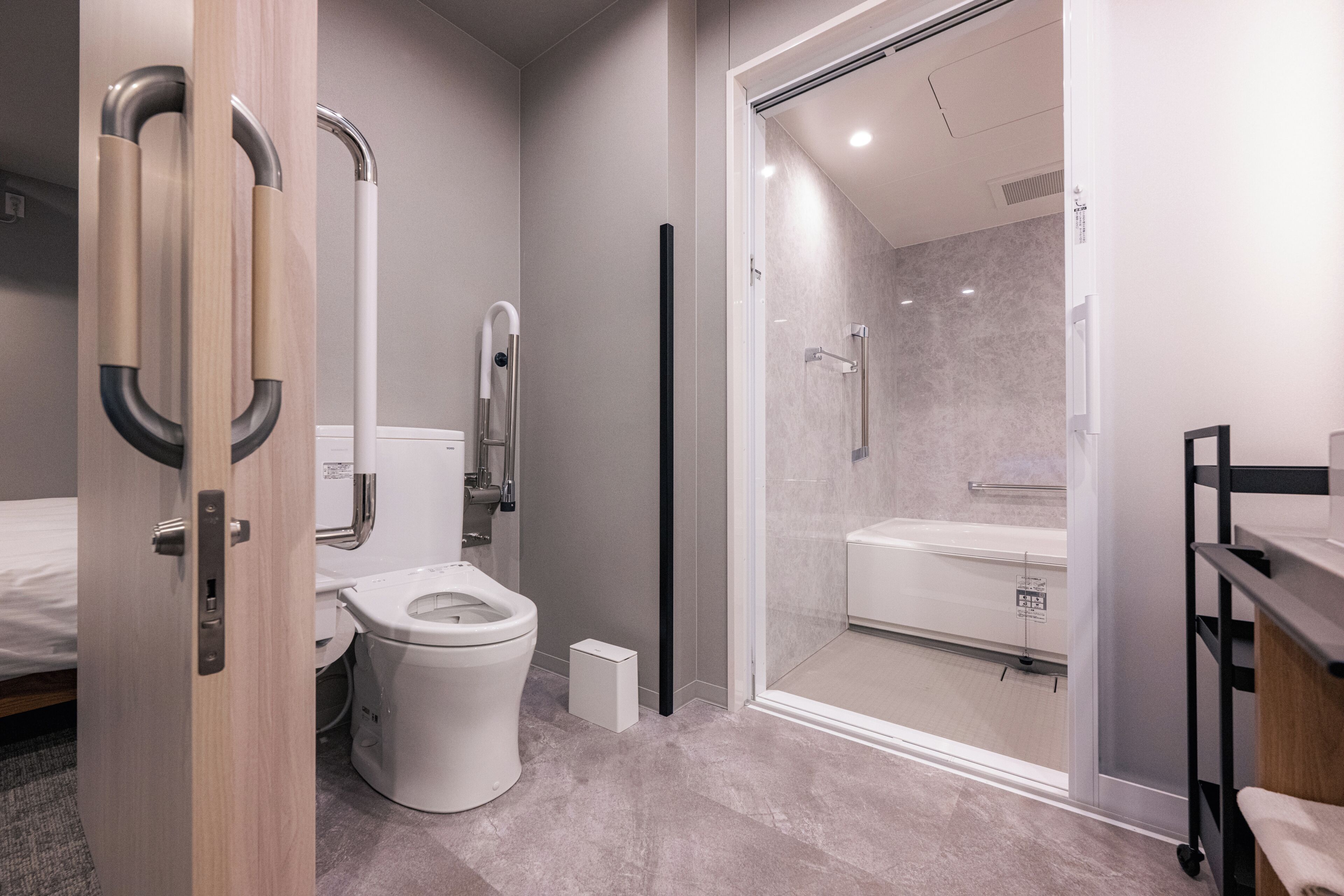 A modern bathroom with a toilet, shower, and glass-enclosed shower stall.