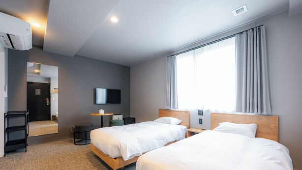A hotel room with two beds, a television, a desk, and a large window with curtains. - Grand Hostel LDK Osaka Shinsekai - Hostel (Osaka)