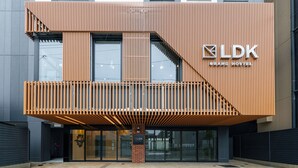A modern building with a prominent LDK Grand Hostel sign, featuring a wooden facade and a balcony. - Grand Hostel LDK Osaka Shinsekai - Hostel (Osaka)