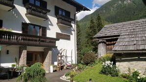 A building with balconies, a stone wall, and a mountain backdrop.