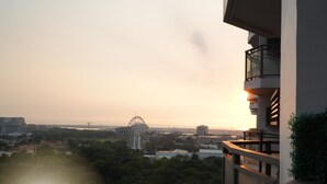 A balcony with a view of a cityscape, including a Ferris wheel and buildings.