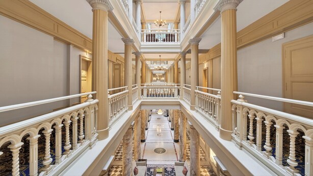 A grand, multi-level interior with ornate railings, columns, and a central staircase. - La Residence des Trois Couronnes (Vevey)