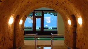 Un intérieur en forme d’arche, doté de bancs et offrant une vue sur une étendue d’eau.
