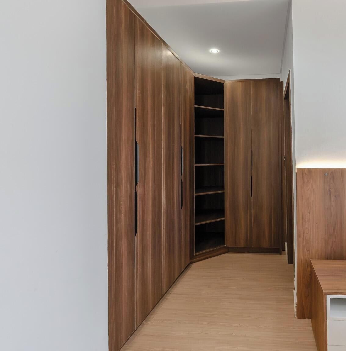 Un couloir doté d’armoires en bois et d’une bibliothèque intégrée.