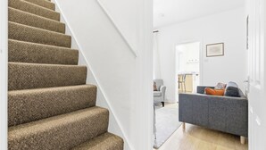 Eine Treppe führt zu einem Wohnbereich mit einem Sofa und einem Sessel.