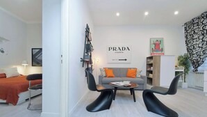 A modern living room with a sofa, two black chairs, a coffee table, and a bookshelf. - 2BR 2BA Historic Center, Metro - Comfort, Quiet (Rome)
